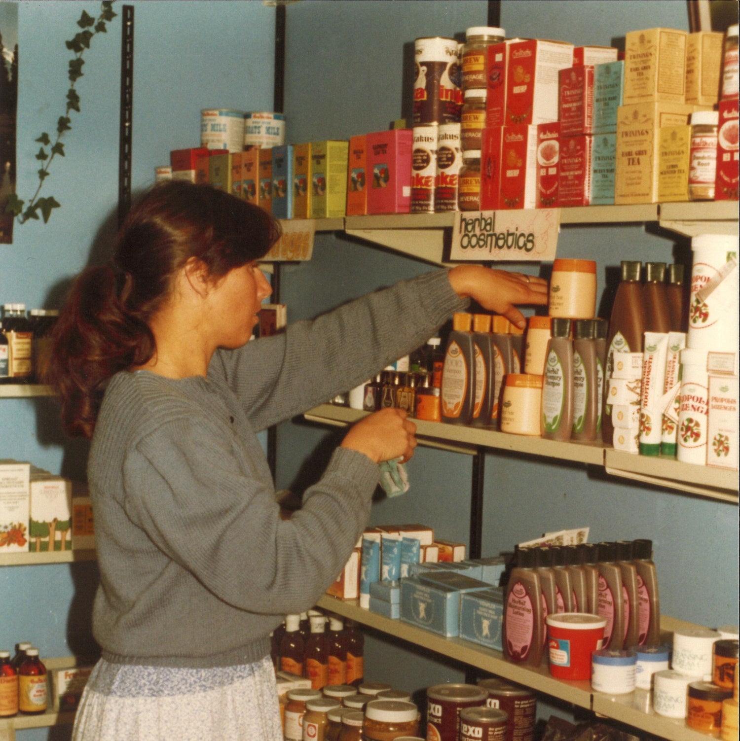 Rita Wilson stocking shelves at Paengaroa shop circa 1975